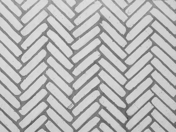 Close-up of a herringbone pattern concrete tile design, perfect for backgrounds and architectural details.